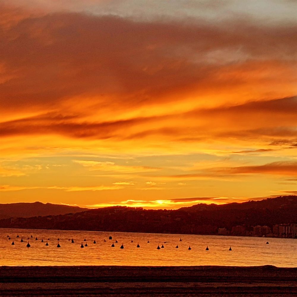 Atardecer sobre el mar visto desde Bell Port, con la costa de Palamós al fondo