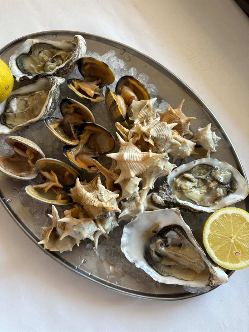 Bandeja de mariscada con ostras, almejas, mejillones y cañaíllas sobre hielo